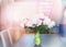 Pink pale peonies bunch on dining table in apartment. Home Interior.