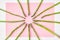 Pink paper background with white borders decorated with asparagus stems like rays of the sun.