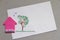 Pink paper house next to childrens drawing of wood and birds. Stay at Home picture. Coronavirus concept