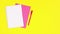 Pink paper, open notebook and pink pencil appear on yellow theme. Stop motion