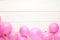 Pink pastel party balloons on white wooden background with copy space for text