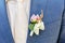 Pink peon boutonniere pinned to a grooms jacket