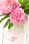 Pink peonies in retro vase on wooden table