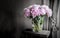 Pink peonies in vase on rustic wooden table. Romantic home decoration.