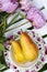 Pink peonies and yellow pears still life in the garden