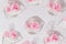 Pink peony flowers inside water filled transparent nylon bags on a grey background.