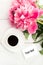 Pink peony flowers with white cup of coffee with note of your is