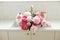 Pink peony and roses flowers in modern kitchen interior, summer floral arrangement in farmhouse. Beautiful peonies in sink on