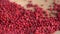 Pink peppercorns placed on a kitchen table. Rotation. Falling. Extreme macro of a Himalayan pepper berries. concept of