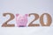 Pink piggy bank with 2020 wooden character, set business goals with new plan on 2020