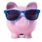 Pink piggy bank blue sunglasses travel money saving concept