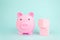 Pink piggy bank with geometric wood blocks cube on blue background