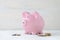 Pink piggy bank with loose cash coins