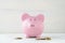 Pink piggy bank with loose cash coins