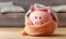 A pink piggy bank money box wrapped up warm with a scarf. Winter heating bills concept