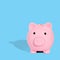 . The pink piggy bank is photographed against a light blue background with hard shadows. Safe savings concept. Creative idea