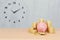 Pink piggy bank and stack of coins on wooden table and blur concrete wall background with copy space