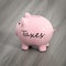 a pink piggy bank with the word taxes