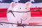 Pink piggy bank wrapped in barbed wire against United States flag as symbol of economic warfare, sanctions and embargo busting