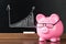 Pink piggybank with glasses on desk