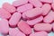 Pink pile of tablets vitamins or pills