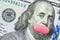 A pink pill covers Franklin& x27;s mouth on a US hundred dollar bill. The concept of feminism, women& x27;s health, the cost of