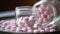 Pink pills in a glass jar. Selective focus. Shallow depth of field.