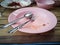 Pink plastic dish, spoon and fork steel are table wooden with copy space