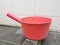 Pink plastic gayung or bucket, scoop, bailer,water dipper on the toilet floor.