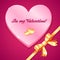 Pink plastic heart with sign and golden bow