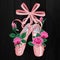Pink pointes female ballet shoes with pink roses flat design on black background.