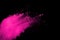 Pink powder explosion on black background. Colored cloud. Colorful dust explode. Paint Holi