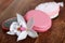 Pink pumice for female feet, soap and orchid on wooden background