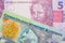 A pink and purple five real bank note from Brazil paired with a colorful one dollar note from the Cayman Islands.