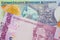 A pink and purple five real bank note from Brazil paired with a colorful one dollar note from the Cayman Islands.