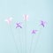 Pink and purple origami butterflies tied to rope for struggle and freedom artistic concept. Blue background and pastel colors