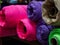 Pink, purple and other rolls of knitted fabric. Woven warehouse