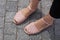 Pink-purple sandals on a girl\'s feet on a gray granite background.