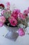 Pink ranunculus flower and pink tulips arranged in iron vase