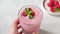 Pink raspberry smoothie in a glass with paper drinking straw