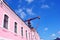 Pink residential house close up, mounting crane on bright blue sky background