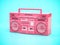 Pink retro boombox ghetto blaster , radio and audio tape recorder on blue background