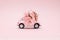 Pink retro toy car delivering bouquet on pink background. February 14, Valentine`s day.. 8 March, International Happy Women`s Day.