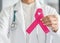 Pink ribbon for breast cancer awareness in doctor`s hand, symbolic bow color for raising awareness campaign on women female