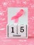 Pink ribbon of breast cancer awareness on a white wooden perpetual calendar with date 15 october. International breast cancer
