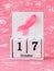 Pink ribbon of breast cancer awareness on a white wooden perpetual calendar with date 17 october. International breast cancer