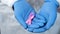 Pink ribbon in doctors hands, breast cancer awareness and prevention campaign