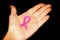 Pink ribbon on the hand. World Breast Cancer Day.