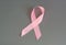 Pink ribbon to raise awareness of breast cancer, the image on a gray background, copy space