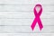 Pink ribbon on wooden background, the concept of female health, the fight against breast cancer